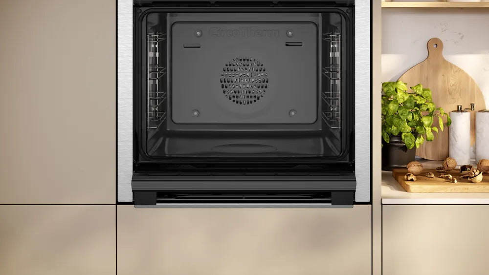 Neff N50 built-in stainless steel oven with open door showing empty interior and fan at the back.