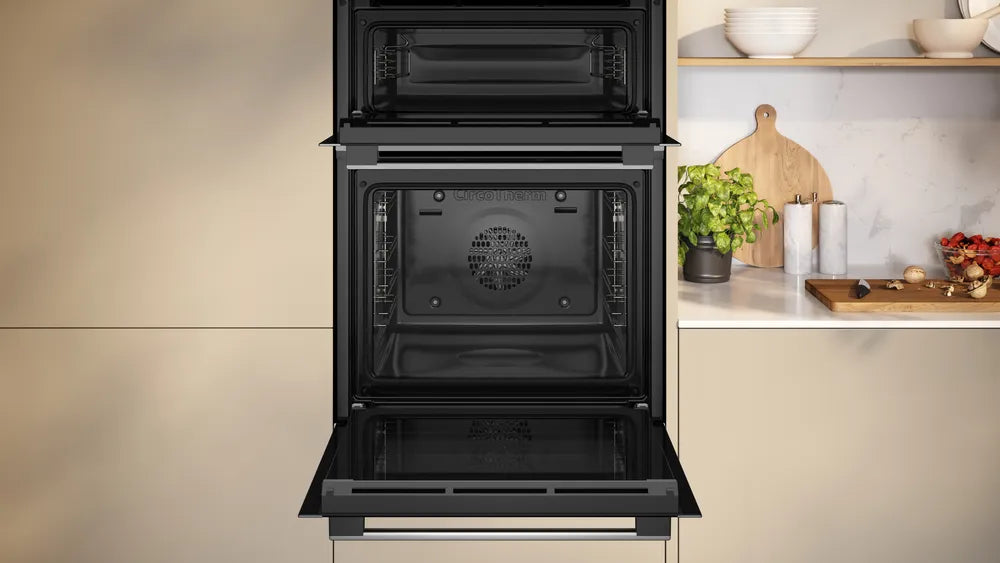 Neff N50 CircoTherm double oven in stainless steel with the lower oven door open in a modern kitchen setting.