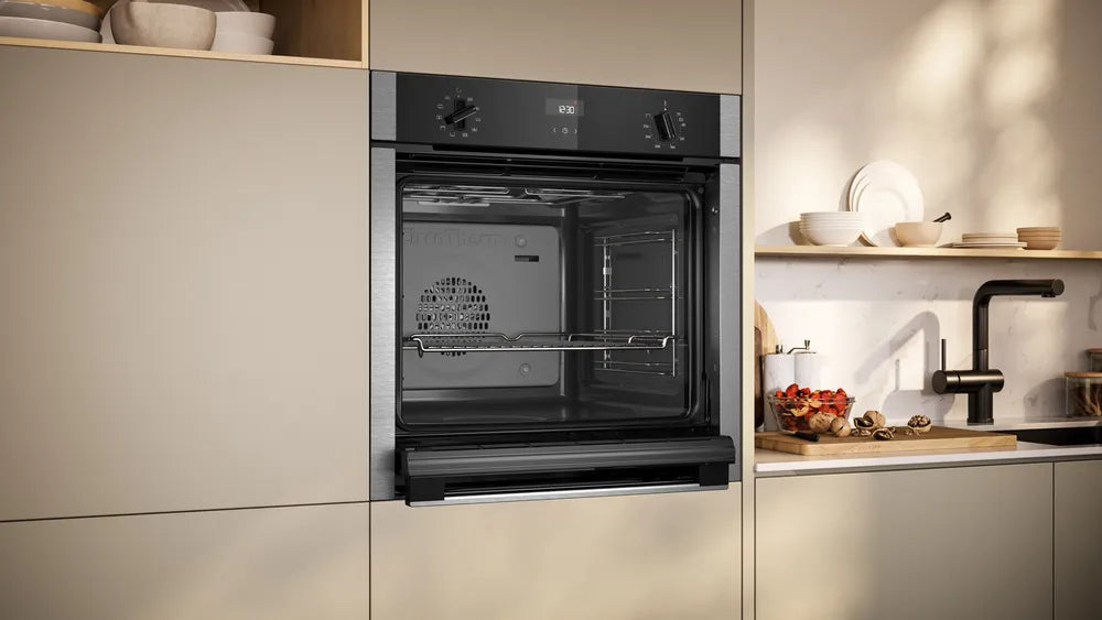 Built-in Neff N50 stainless steel oven with open door, showing interior rack and control knobs.