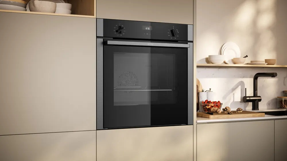Built-in Neff N50 stainless steel oven integrated into beige kitchen cabinetry with digital display and control knobs.