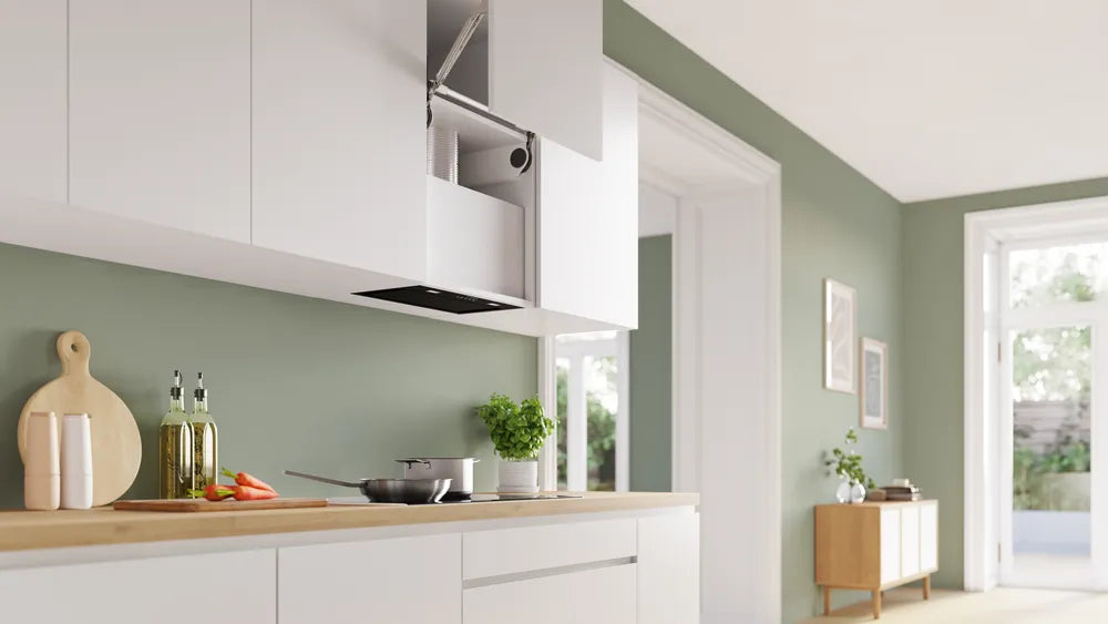 Bosch Series 6 black canopy cooker hood installed under white kitchen cabinets above a stove with pots.