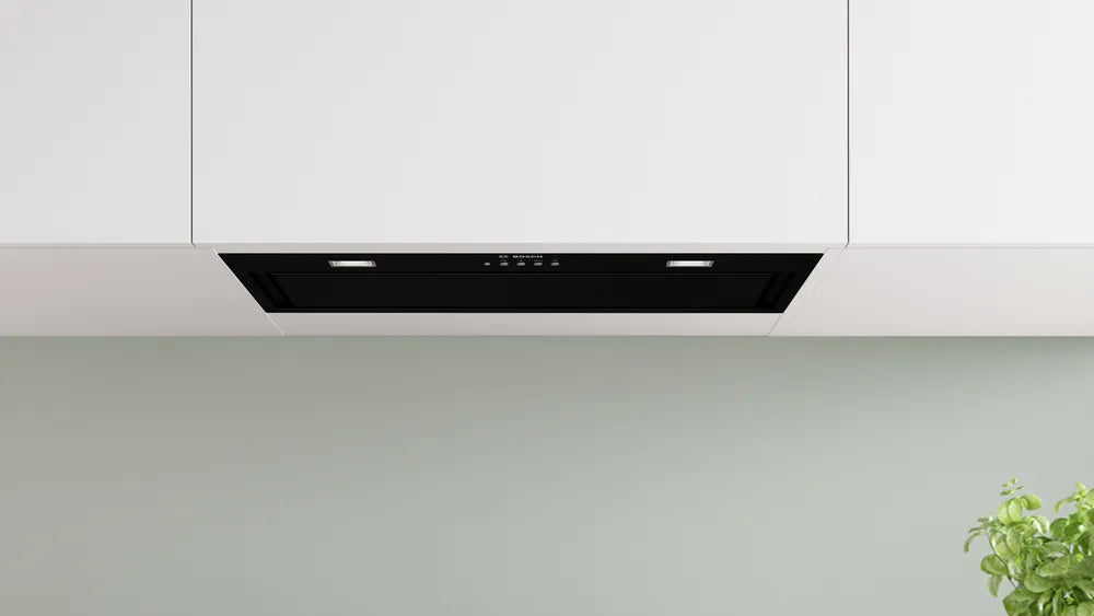 Black Bosch Series 6 canopy cooker hood installed under white kitchen cabinets with control panel and lights visible