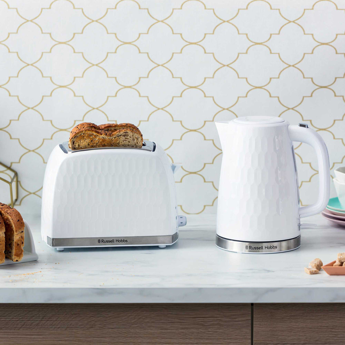 White Russell Honeycomb Hobbs toaster with two slices of seeded bread on a kitchen counter.