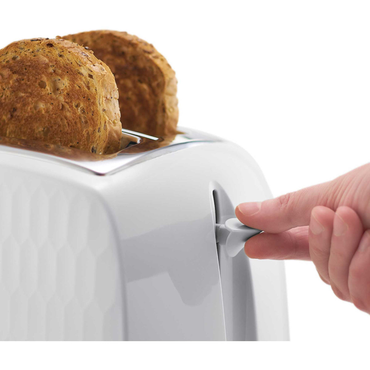 Close-up of a hand pressing the lever on a white Russell Honeycomb Hobbs toaster with two slices of seeded bread.