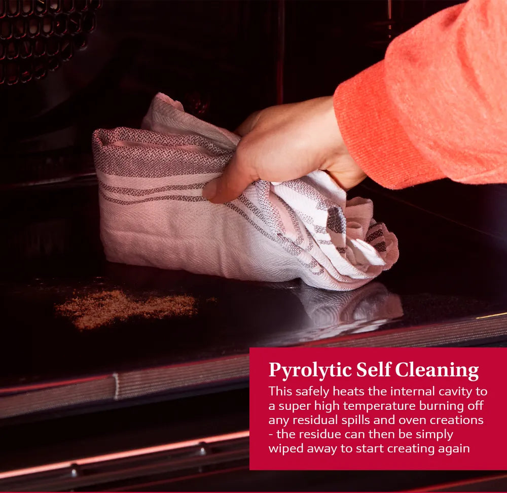 Hand wiping residue inside the NEFF N70 Slide&Hide B54CR71N0B oven cavity demonstrating pyrolytic self-cleaning feature.