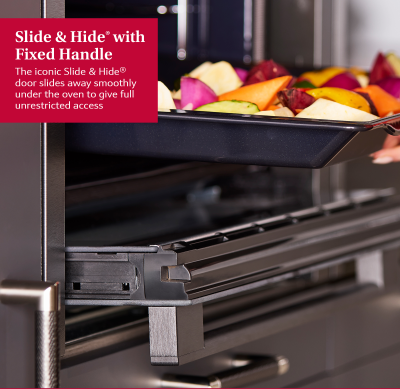 NEFF Graphite N50 Slide & Hide oven door slid under oven with tray of roasted vegetables being removed.