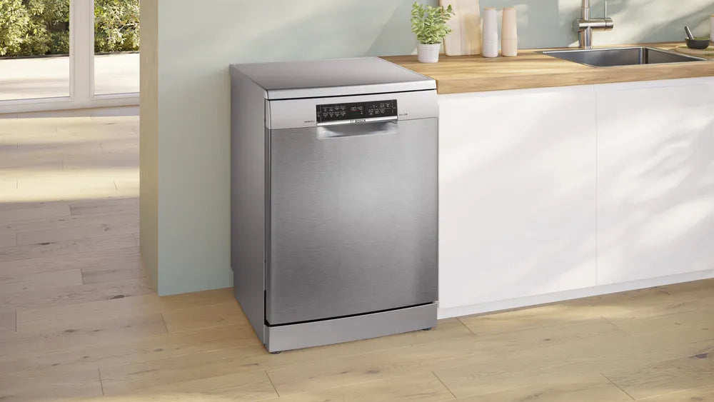 Bosch Series 6 free-standing dishwasher in brushed steel with digital display, placed next to a kitchen counter.