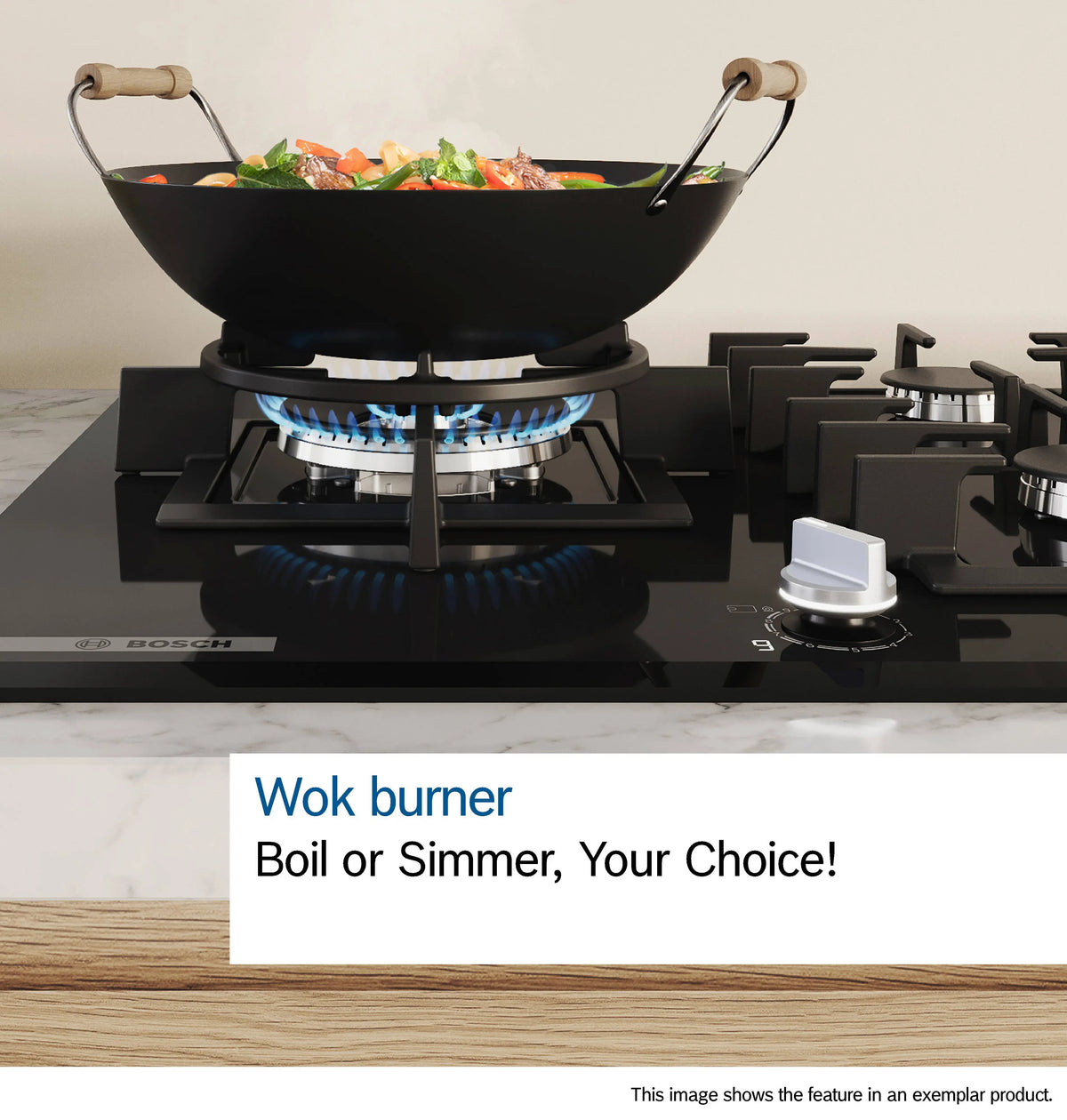 Black Bosch gas hob burner with a wok pan cooking vegetables on a blue flame flame