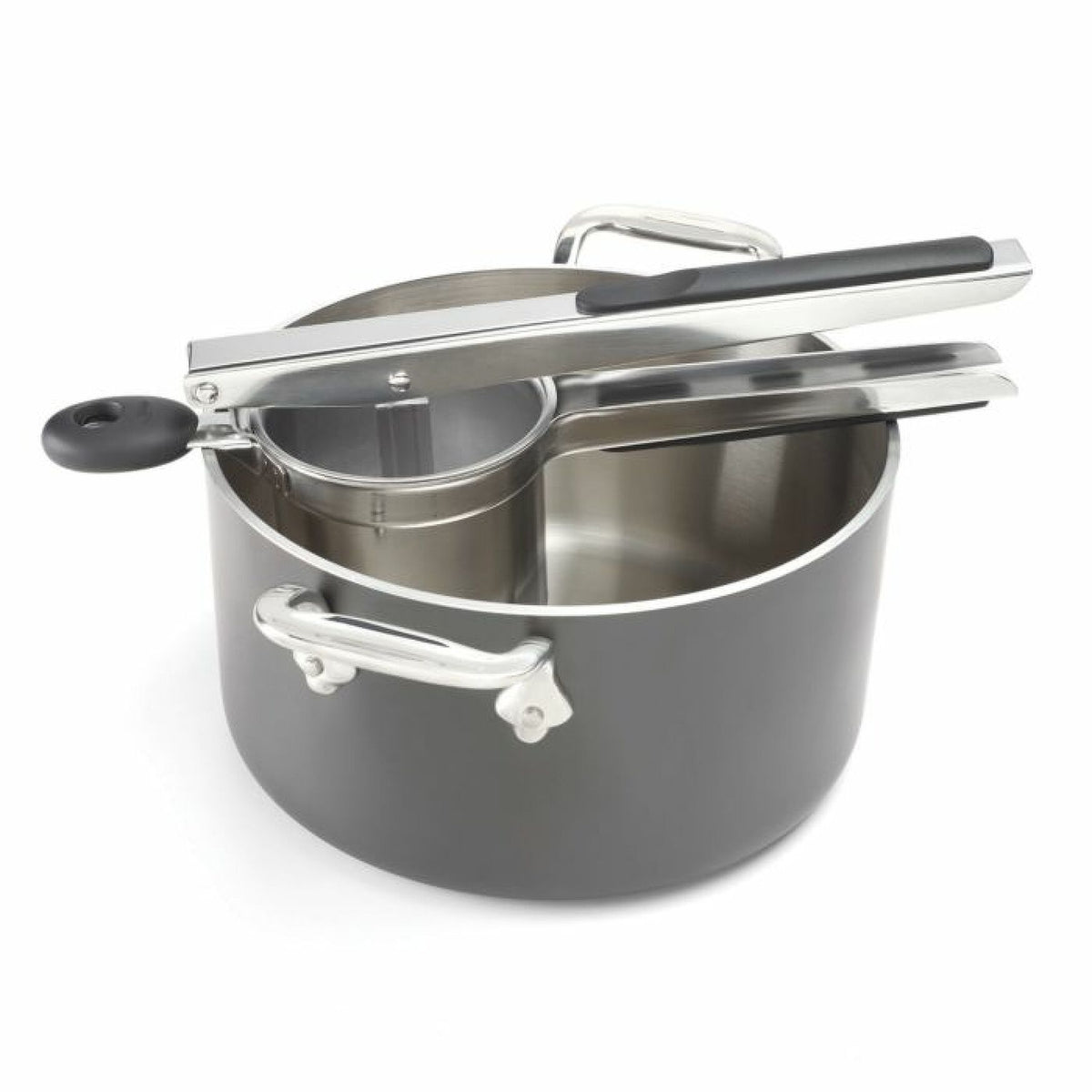 Oxo Potato Ricer resting on the edge of a black cooking pot with metal handles on white background