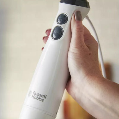 Hand holding a white Russel Hobbs Stick Hand Blender 3n1 showing control buttons and logo.