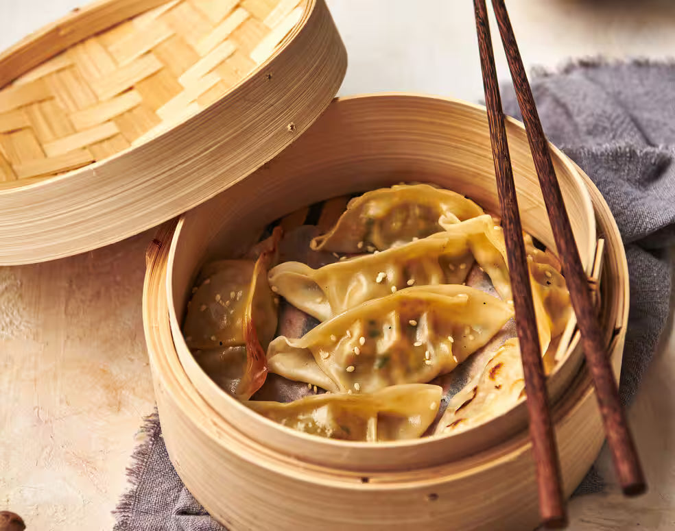 Kenwood Meat Grinder Attachment not visible; image shows steamed dumplings in a bamboo steamer with chopsticks.