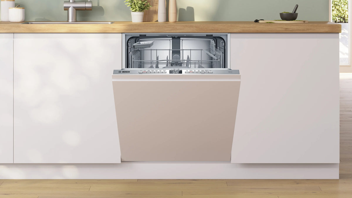 Bosch Series 4 fully integrated dishwasher with open door, showing empty stainless steel interior racks.