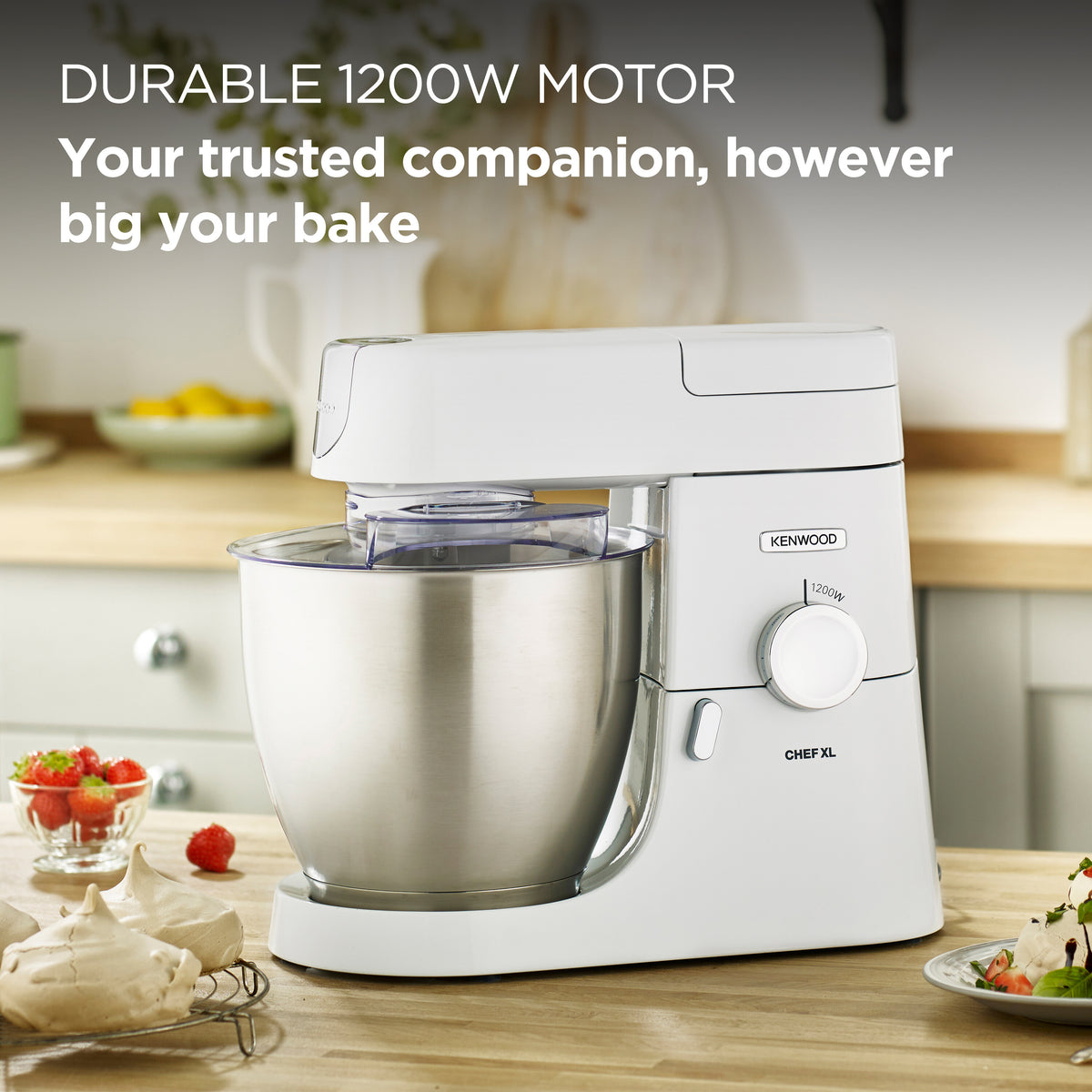 Kenwood Chef Mixer XL in white with stainless steel bowl on kitchen counter with strawberries and meringues nearby