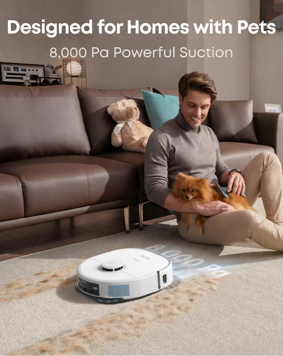 Eufy X10 Pro Omni robot vacuum cleaning pet hair on carpet near man sitting with small dog on floor.