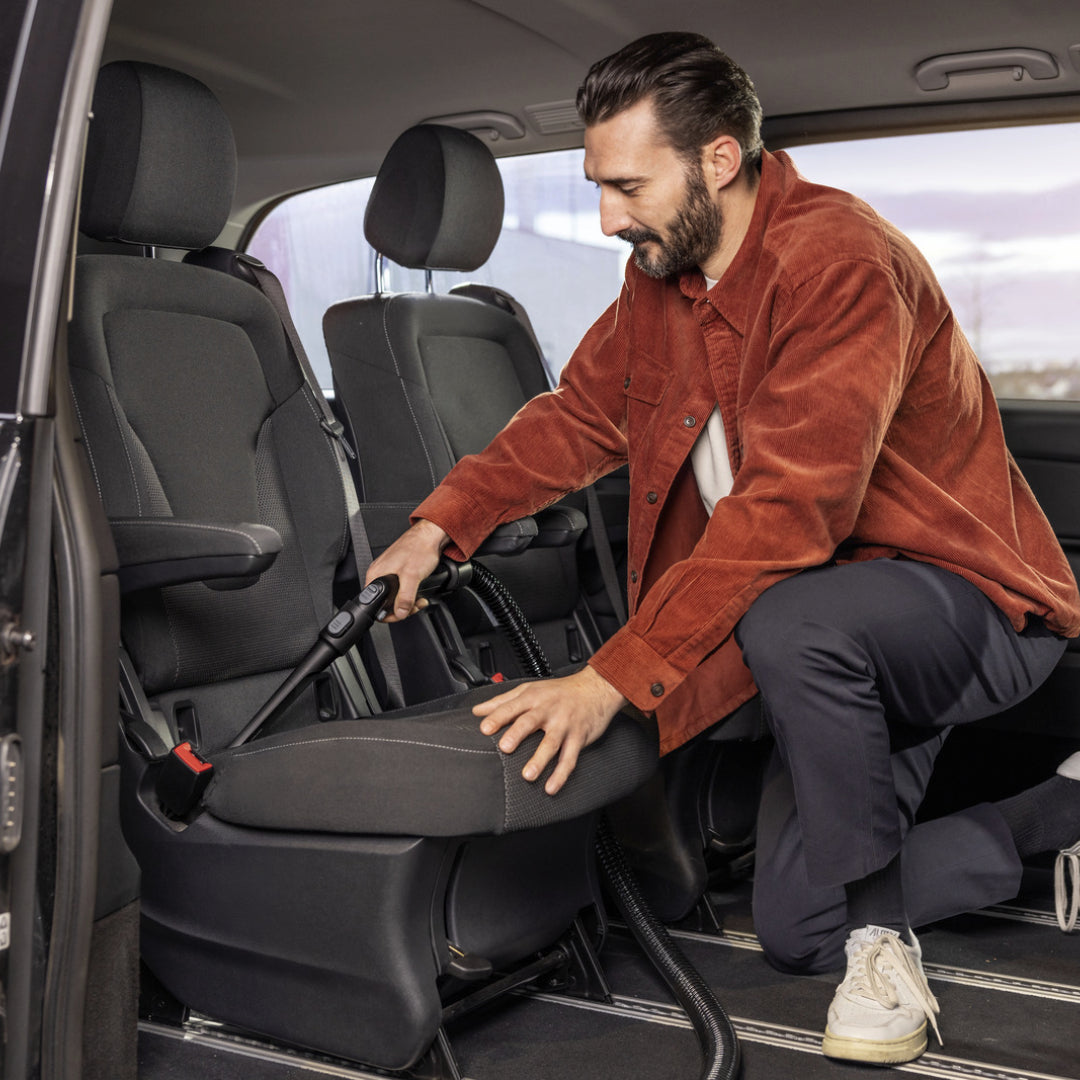 Man using Karcher SE4 Select Carpet Cleaner Vacuum to clean a car seat interior upholstery.