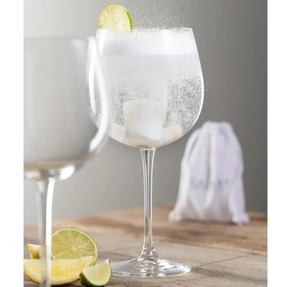 Clear glass with white jade cooling stones inside, garnished with a lime wedge on the rim.