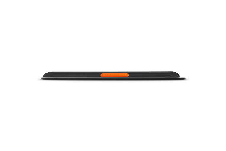 Side view of Le Creuset insulated cookie sheet showing slim profile and orange silicone grip handle.