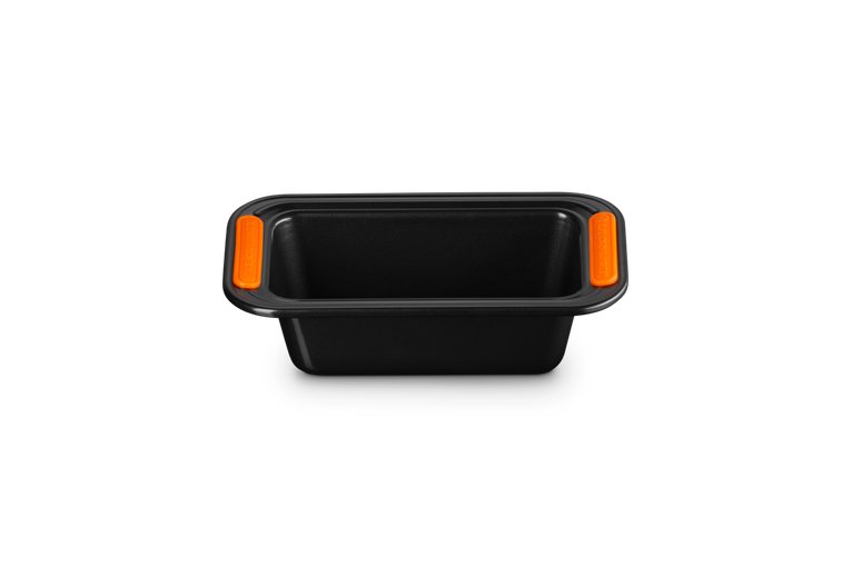 Le Creuset 1LB black non-stick loaf tin with orange silicone grip handles, front view on white background