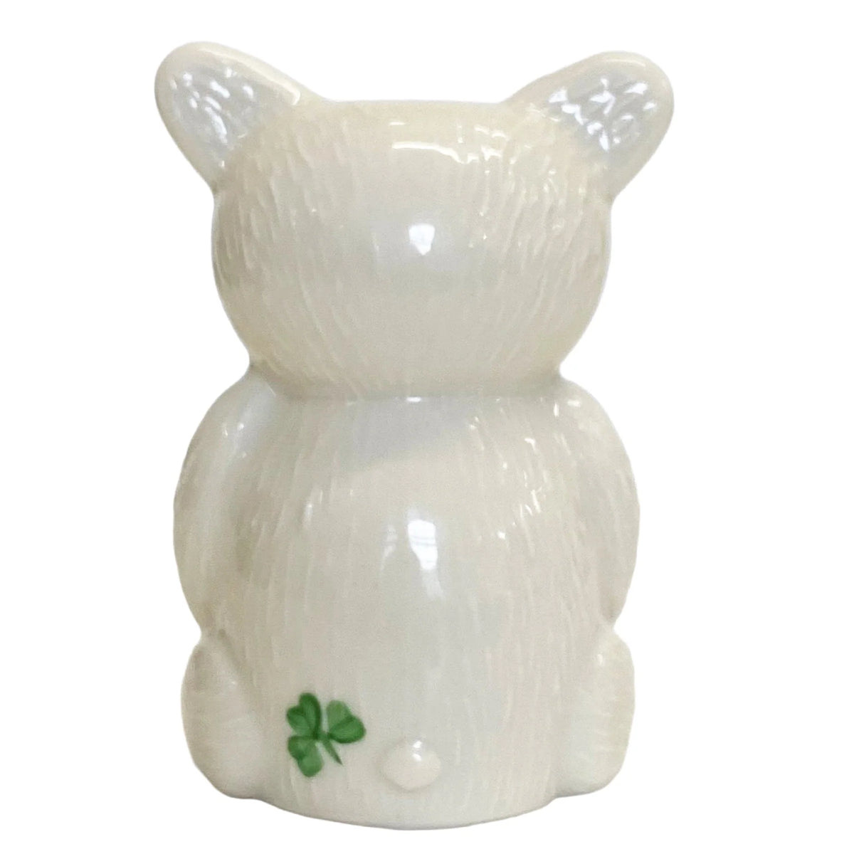 Glossy white ceramic Belleek teddy ornament with textured fur and a small green shamrock on its foot.