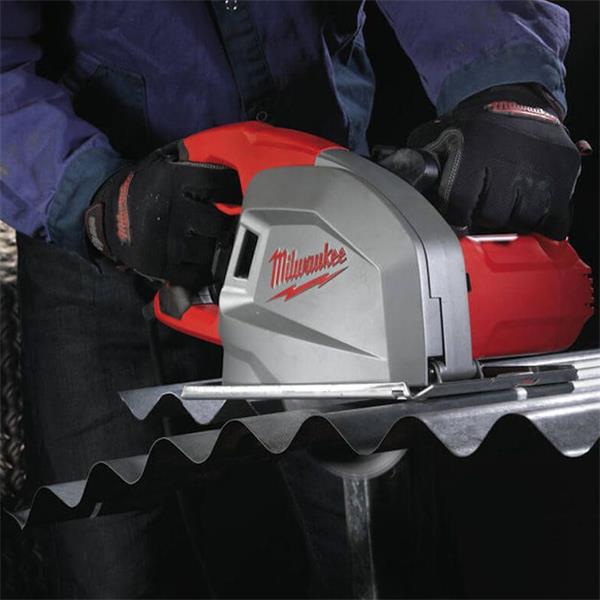 Milwaukee circular saw blade cutting corrugated metal sheet, held by gloved hands