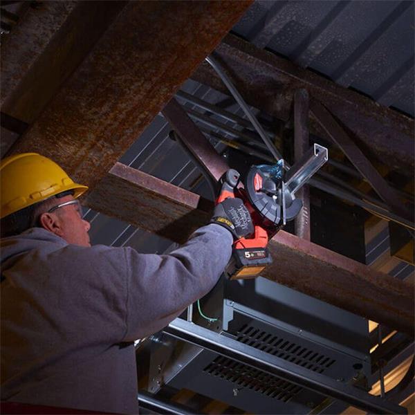 Worker wearing a yellow hard hat using a Milwaukee circular saw with a blade cutting metal beams overhead