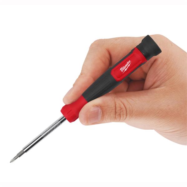 Hand holding a Milwaukee 27 in 1 multi-bit screwdriver with red and black handle and extended bit.