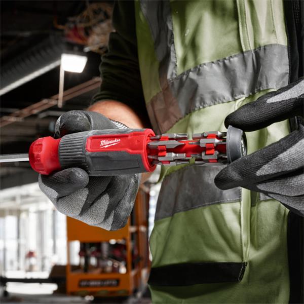 Milwaukee 27 in 1 multi-bit screwdriver held by a worker showing the bit storage inside the handle.
