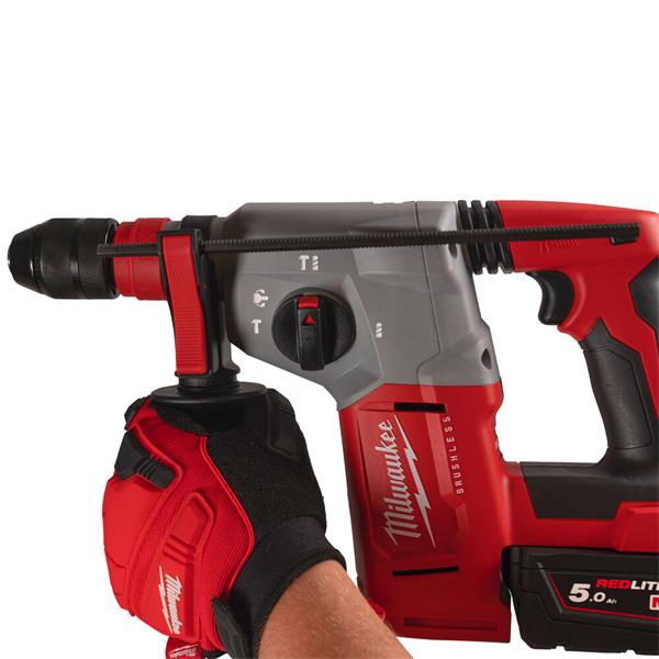 Milwaukee M18BLHX-0 brushless SDS+ hammer drill held by a hand wearing a red and black glove, side view.