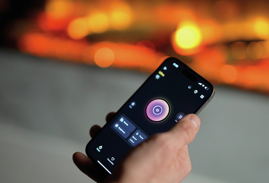 Hand holding smartphone displaying Dimplex Ignite Ultra 74 remote control app with power and heat settings visible