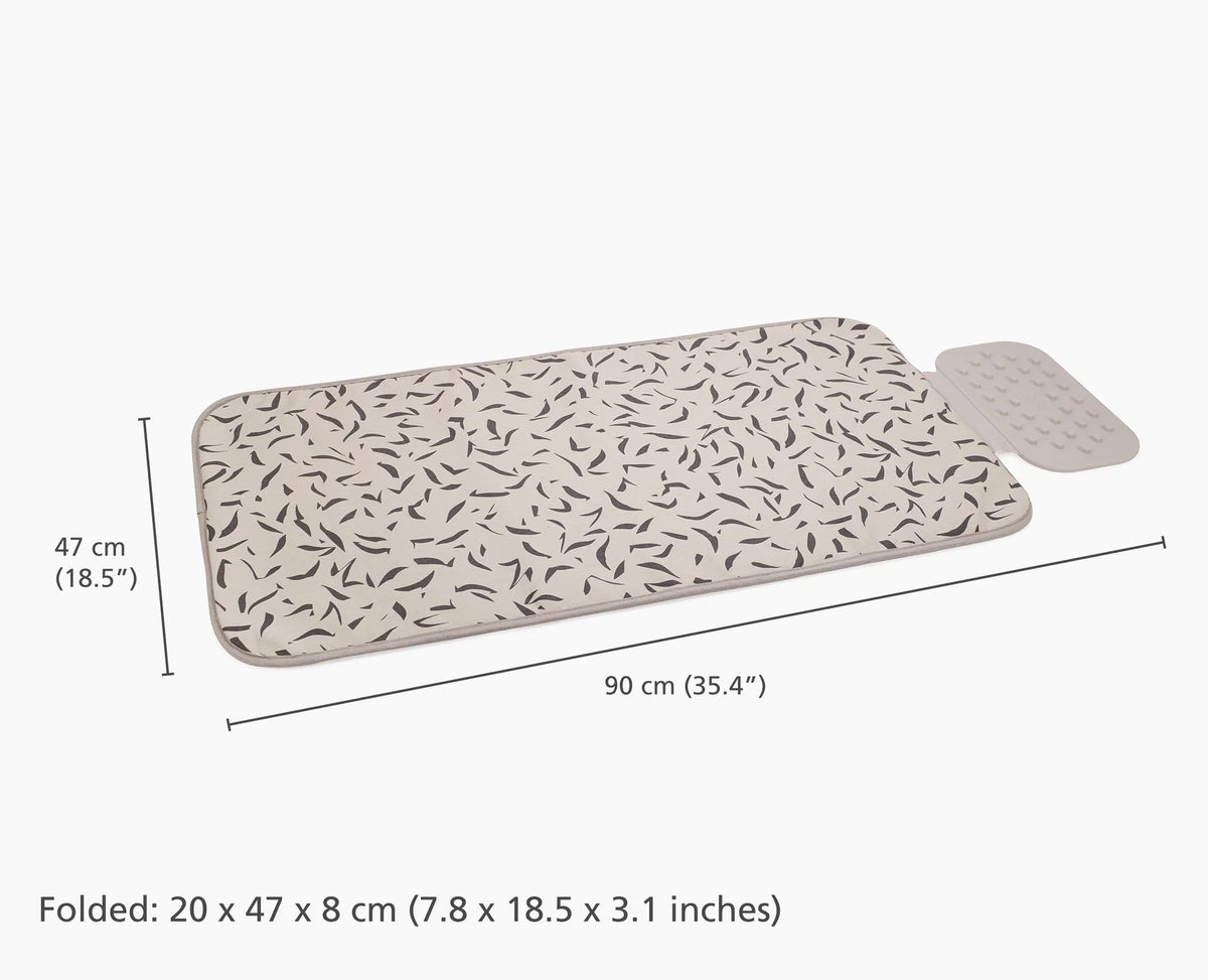 Ecru ironing mat with black scattered leaf pattern and attached silicone iron rest, shown with dimensions.