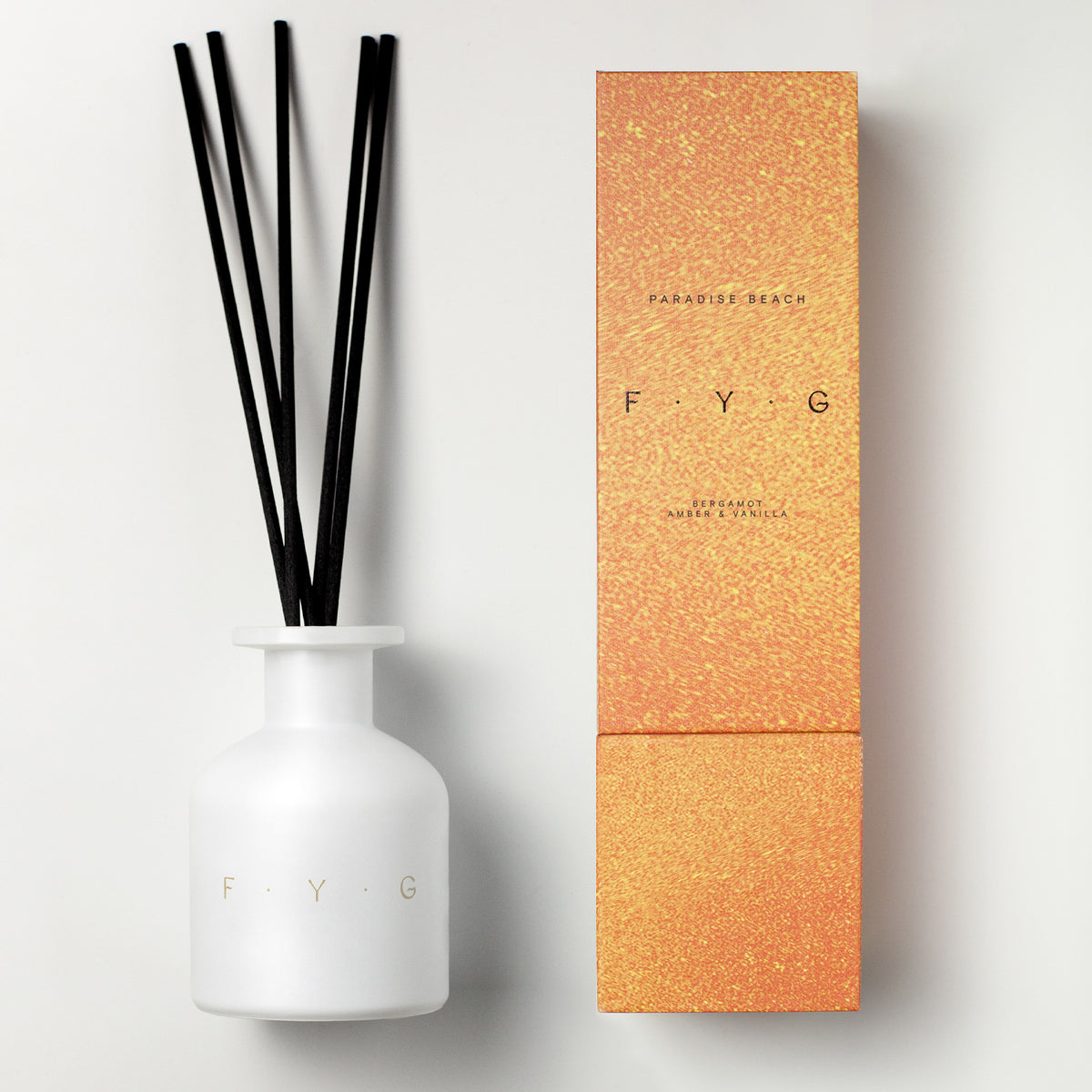 White Paradise Beach Diffuser F.Y.G bottle with black reeds next to textured orange packaging box.