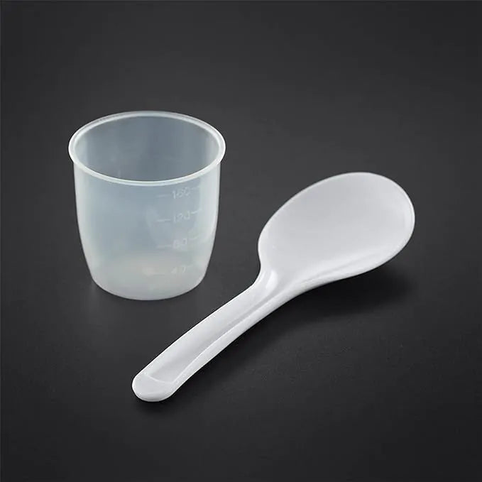 Measuring cup and white plastic rice paddle for Russel Hobbs Rice Cooker on black background