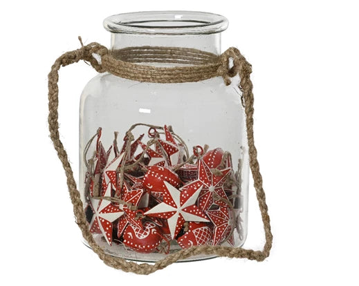 Glass jar filled with red and white star and bell hangers with jute hanging loop around the jar.