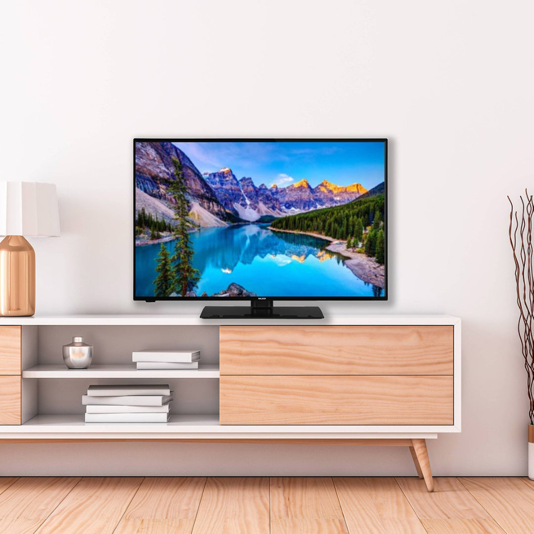 Walker 32'' QLED Smart TiVo TV on a modern white and wood media console showing a mountain lake scene.