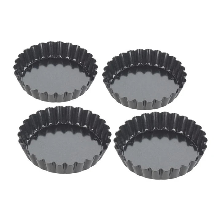 Set of four black metal tart tins with fluted edges, shown from above on white background.