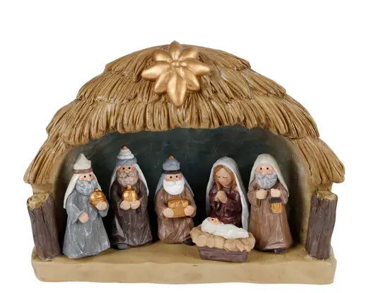 A nativity scene figurine set featuring a thatched-roof stable with six painted characters, including Mary, Joseph, baby Jesus in a manger, and three wise men, on a plain white background.