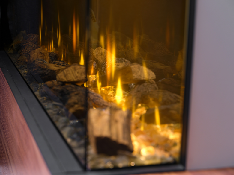 Close-up of the Dimplex Ignite Bold 60″ electric fire showing glowing logs and flickering flames behind glass.
