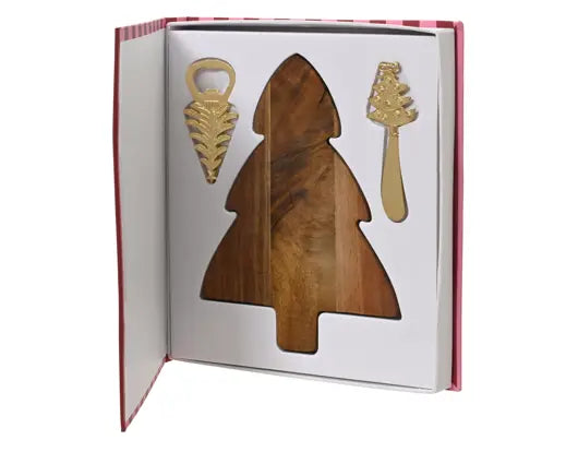 A Christmas-themed gift set in a book-shaped presentation box, featuring a wooden tree-shaped serving board with a cutout, a gold-tone bottle opener, and a gold-tone serving utensil on a white insert.