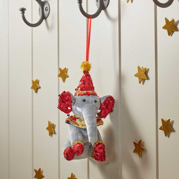 A gray elephant plush ornament decorated with red sequins and a red sequin party hat