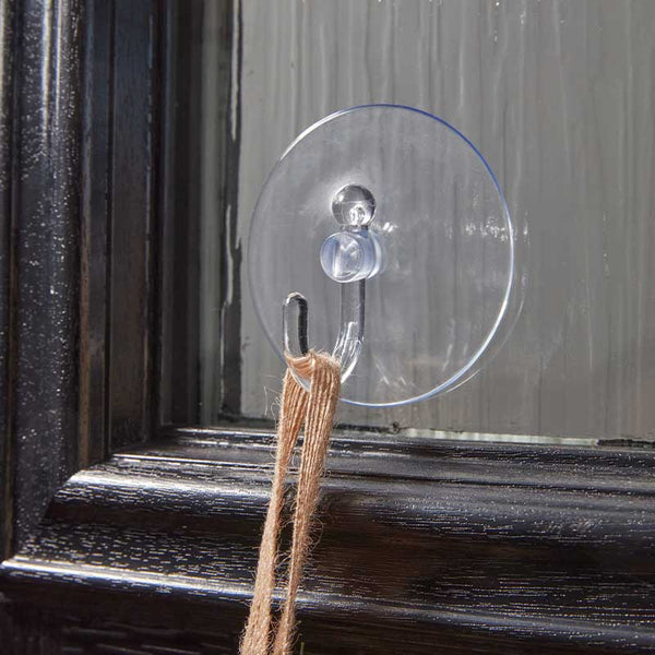 Clear suction cup with a string attached to a wooden surface