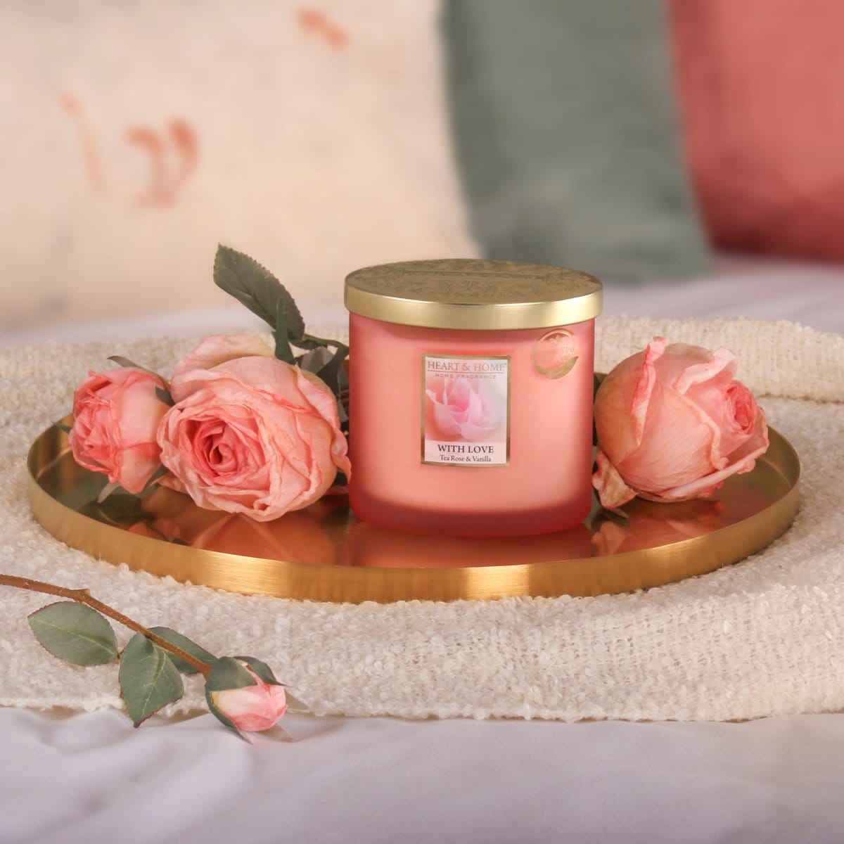 Heart & Home Twin Wick Ellipse candle in pink glass with gold lid, surrounded by pink roses on a gold tray