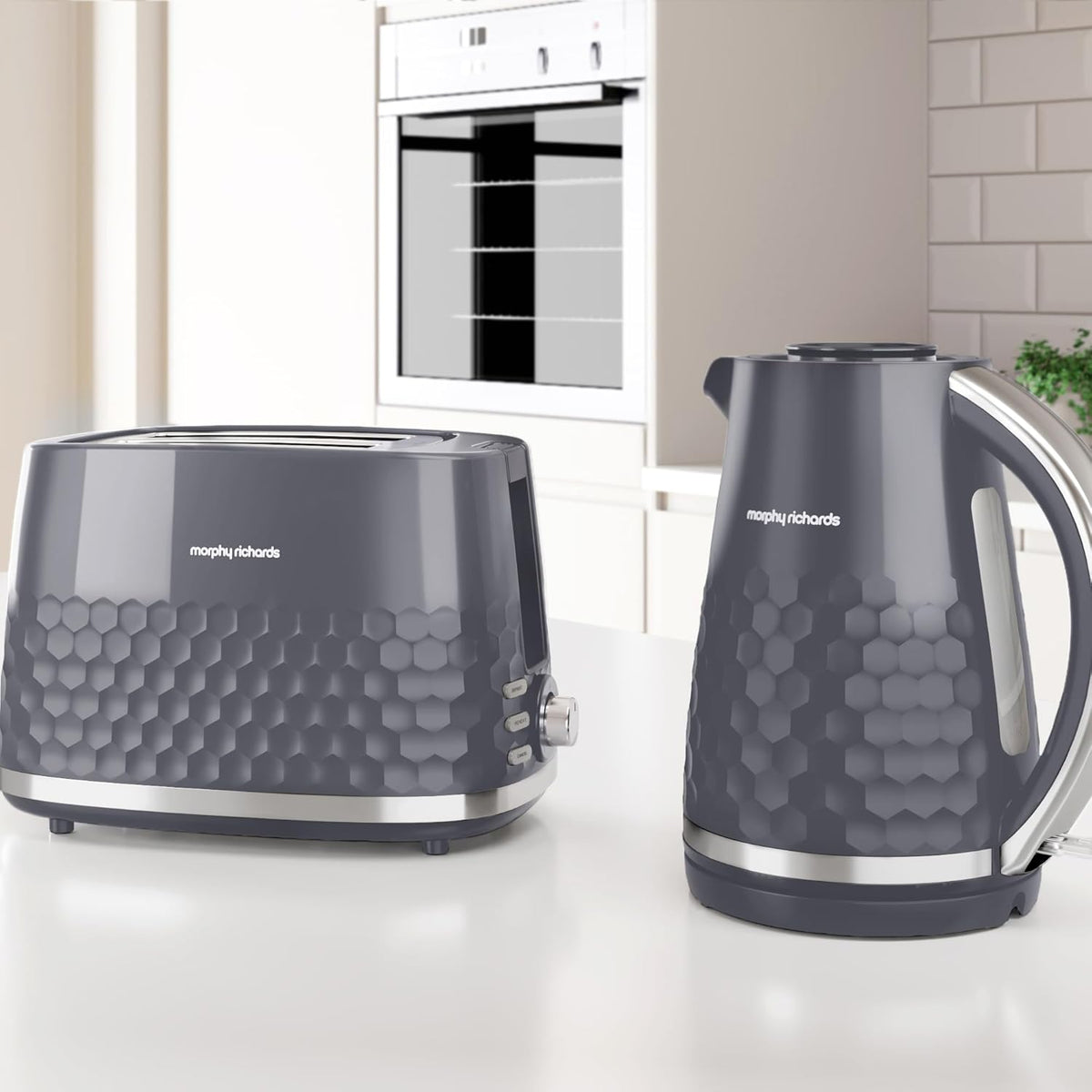 Grey Morphy Richards Hive kettle with honeycomb pattern on a kitchen counter next to a matching toaster