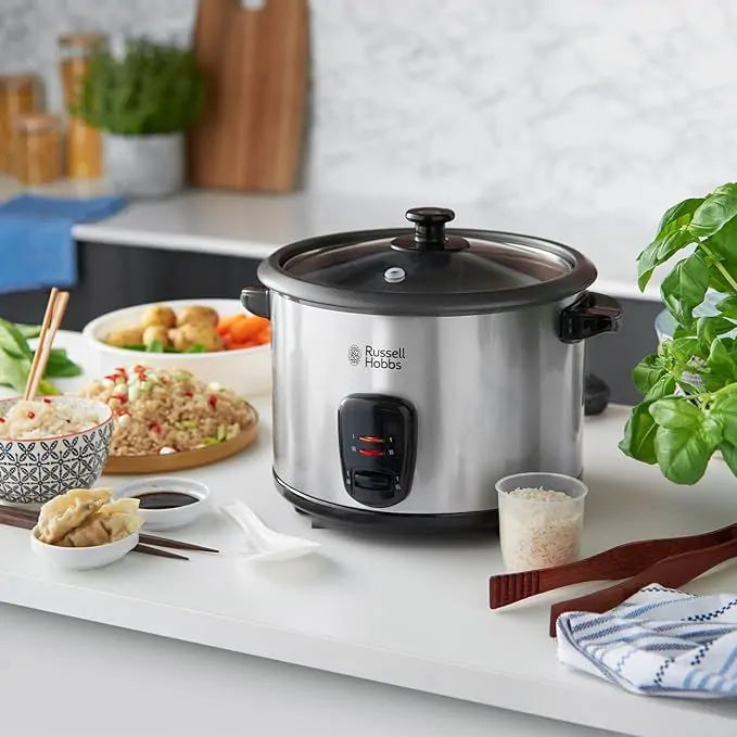 Russell Hobbs rice cooker with glass lid on kitchen counter surrounded by bowls of food and utensils