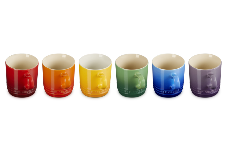 Set of six Le Creuset cappuccino mugs in red, orange, yellow, green, blue, and purple, front view.