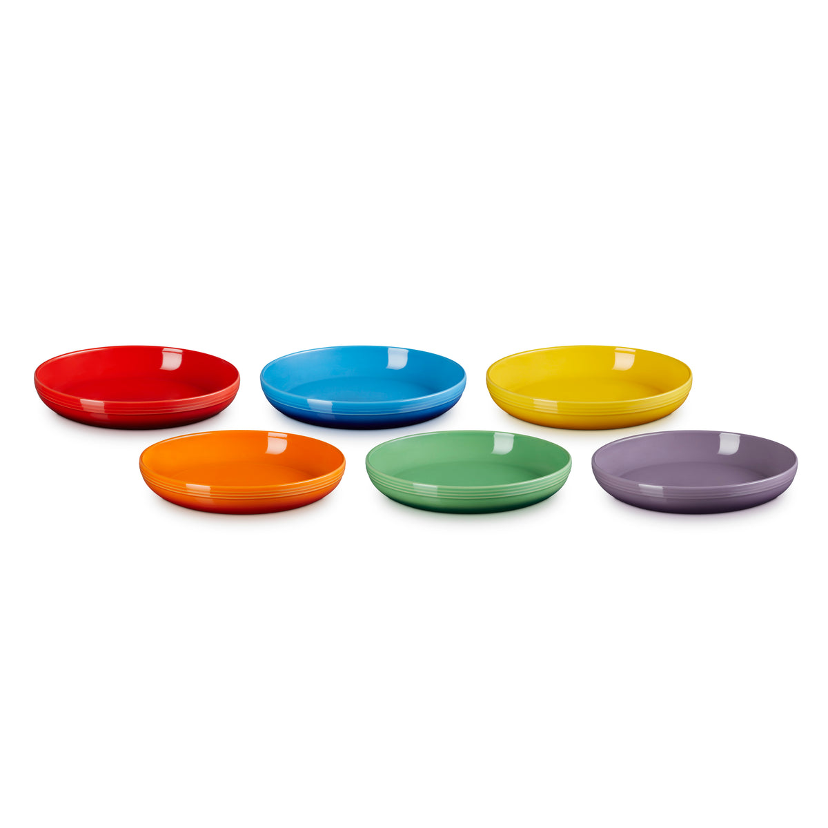 Six colorful Le Creuset coupe pasta bowls in red, blue, yellow, orange, green, and purple, arranged in two rows.