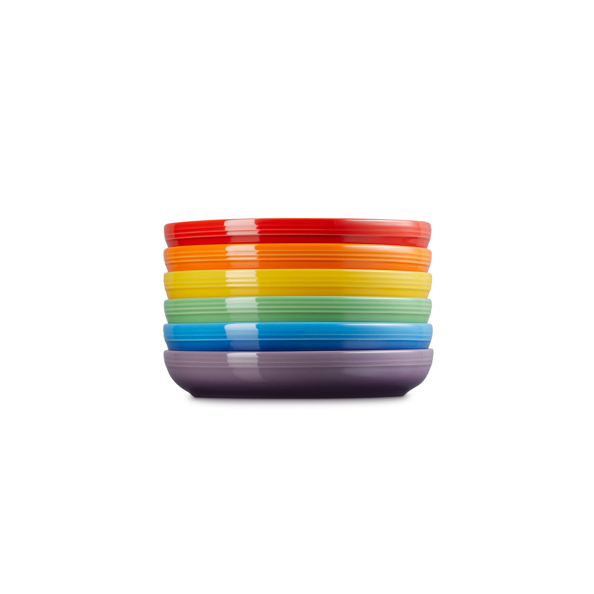 Stacked Le Creuset Rainbow set of six colorful coupe pasta bowls in red, orange, yellow, green, blue, and purple.