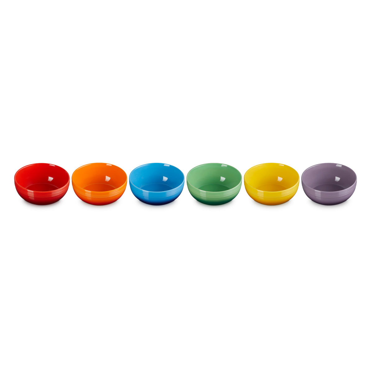 Six colorful Le Creuset coupe cereal bowls in red, orange, blue, green, yellow, and purple, front view.