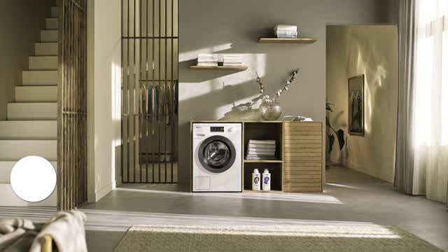Miele 8kg front-loading washing machine integrated into a modern laundry room with wooden shelving and natural light.