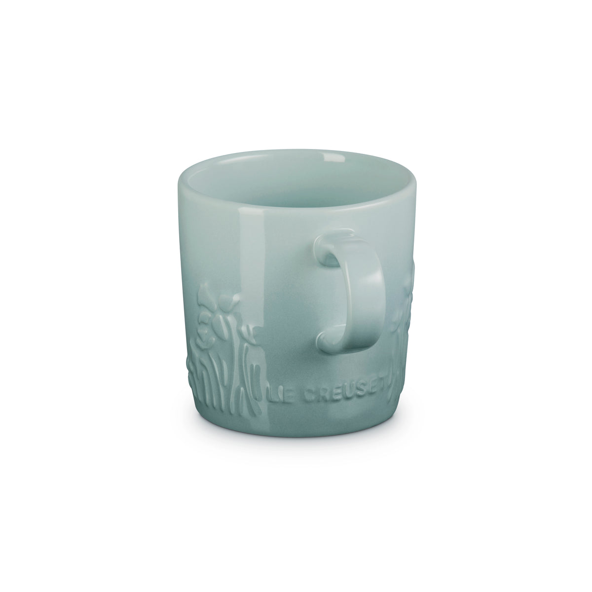 Le Creuset London Mug in sea salt color with embossed floral design and handle, front view.