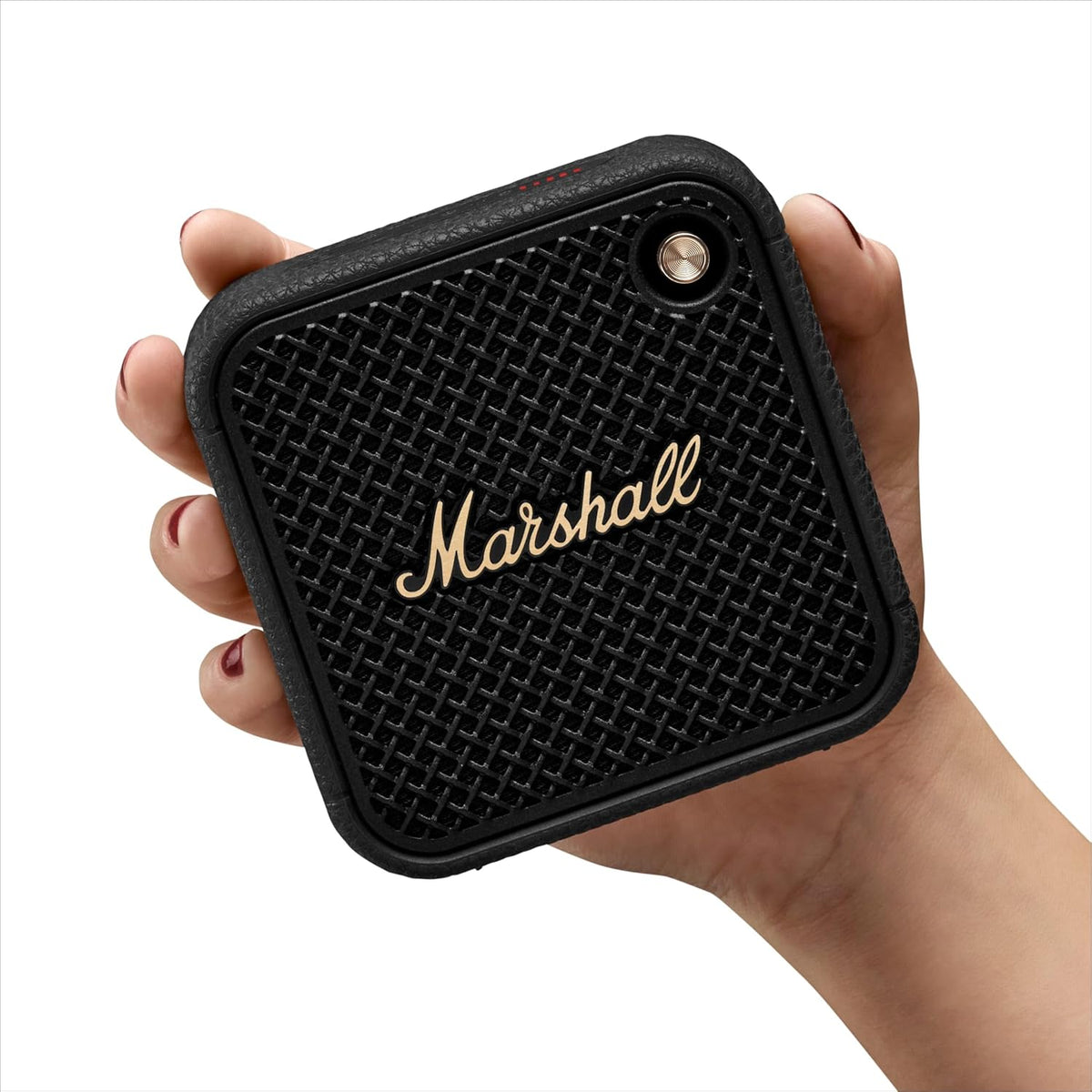 Hand holding a compact Marshall Willen II Black & Brass portable speaker with textured grille and logo.